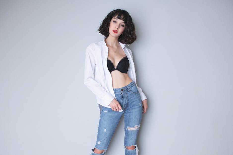 Stylish young woman posing in casual fashion attire in a studio setting.