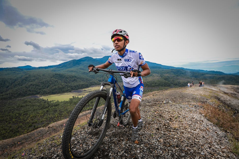 A mountain biker pushes uphill on a rugged trail in Mich., Mexico, set against mountain scenery.