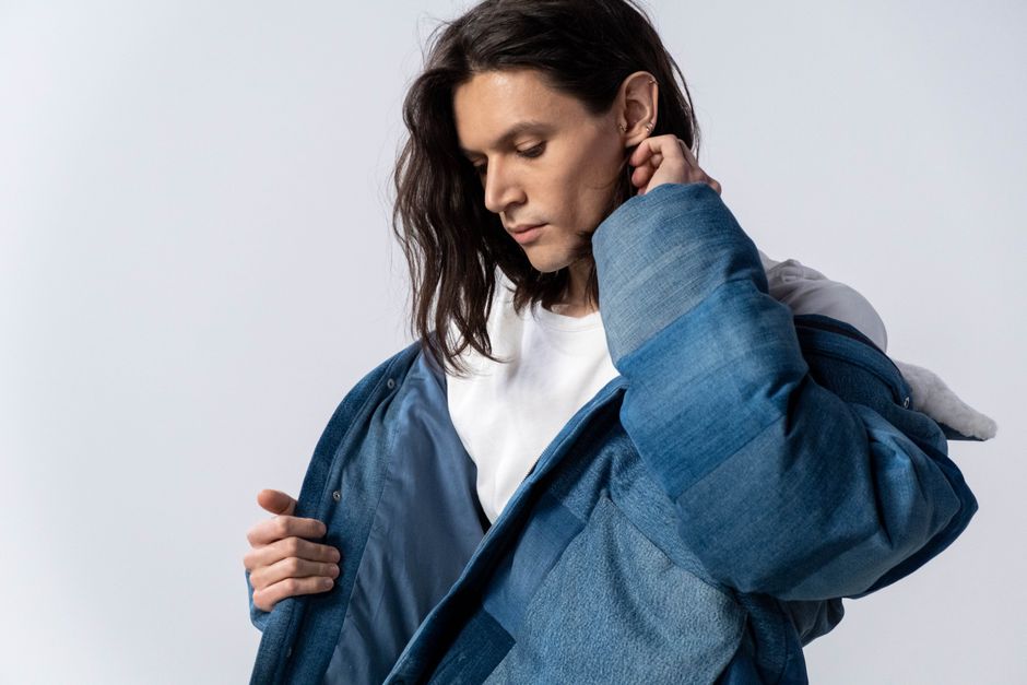 Trendy young man wearing denim jacket and white shirt in studio.