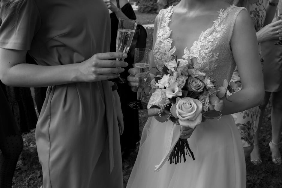 Close-up of a bride holding a bouquet and champagne at a wedding.